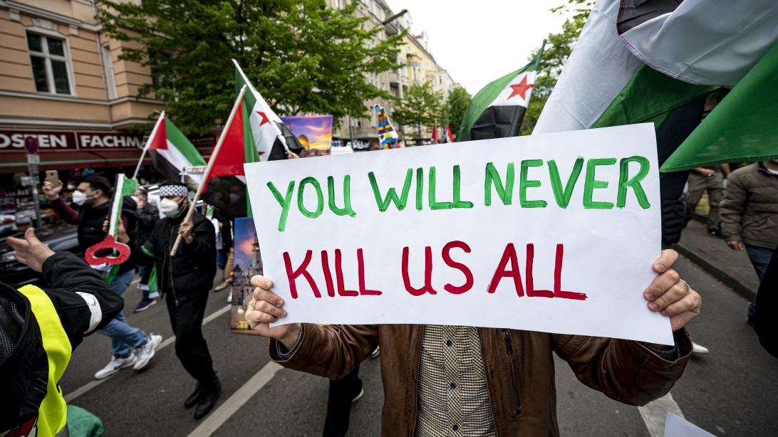 Die Aufnahme zeigt Demonstrierende am 15.05.2021 in Berlin mit einem Schild "You will never kill us all"