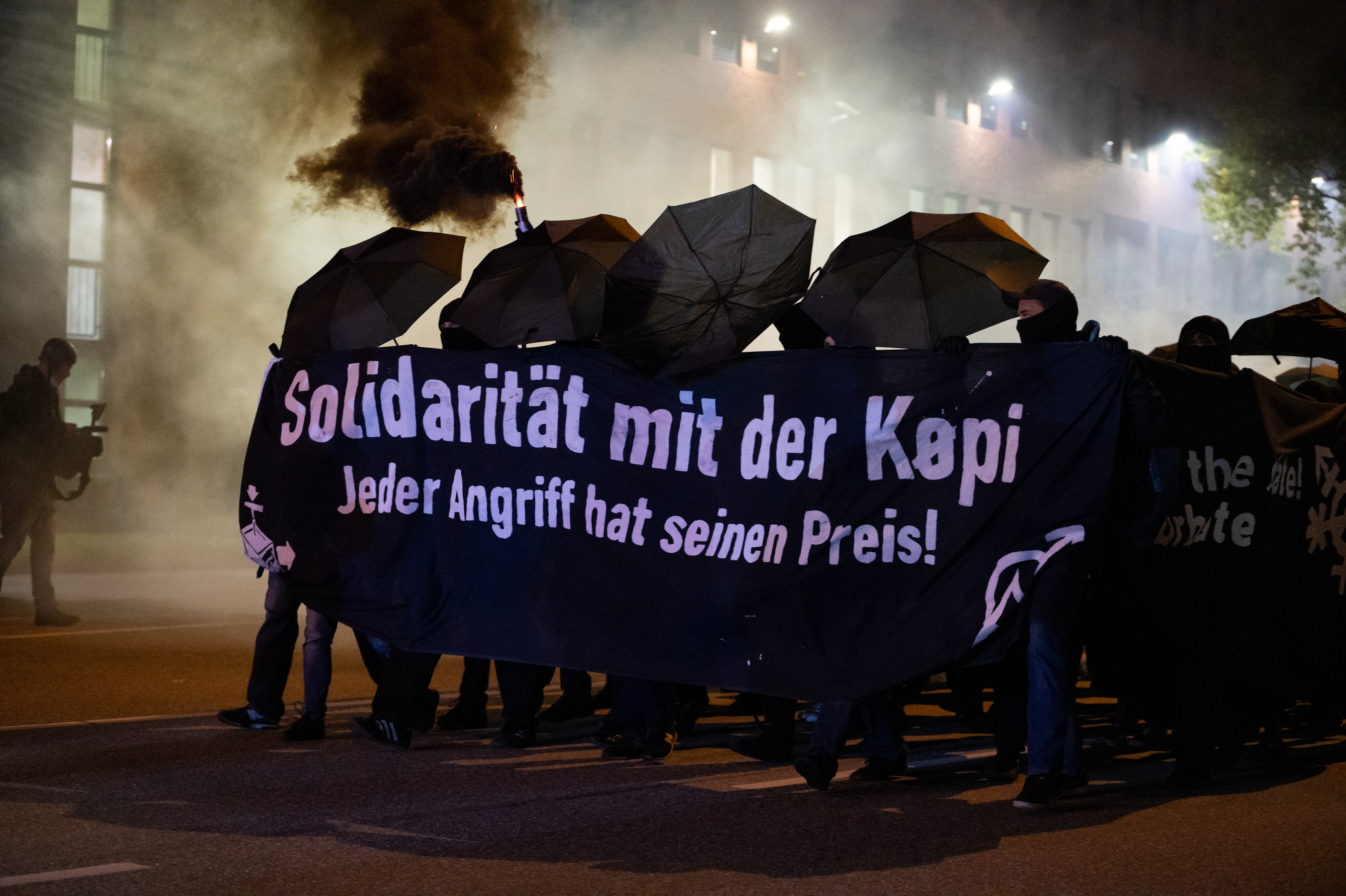 Demonstrierende Personen am 15.10.2021 in Berlin mit einem schwarzen Transparent und der Aufschrift "Solidarität mit der Köpi"
