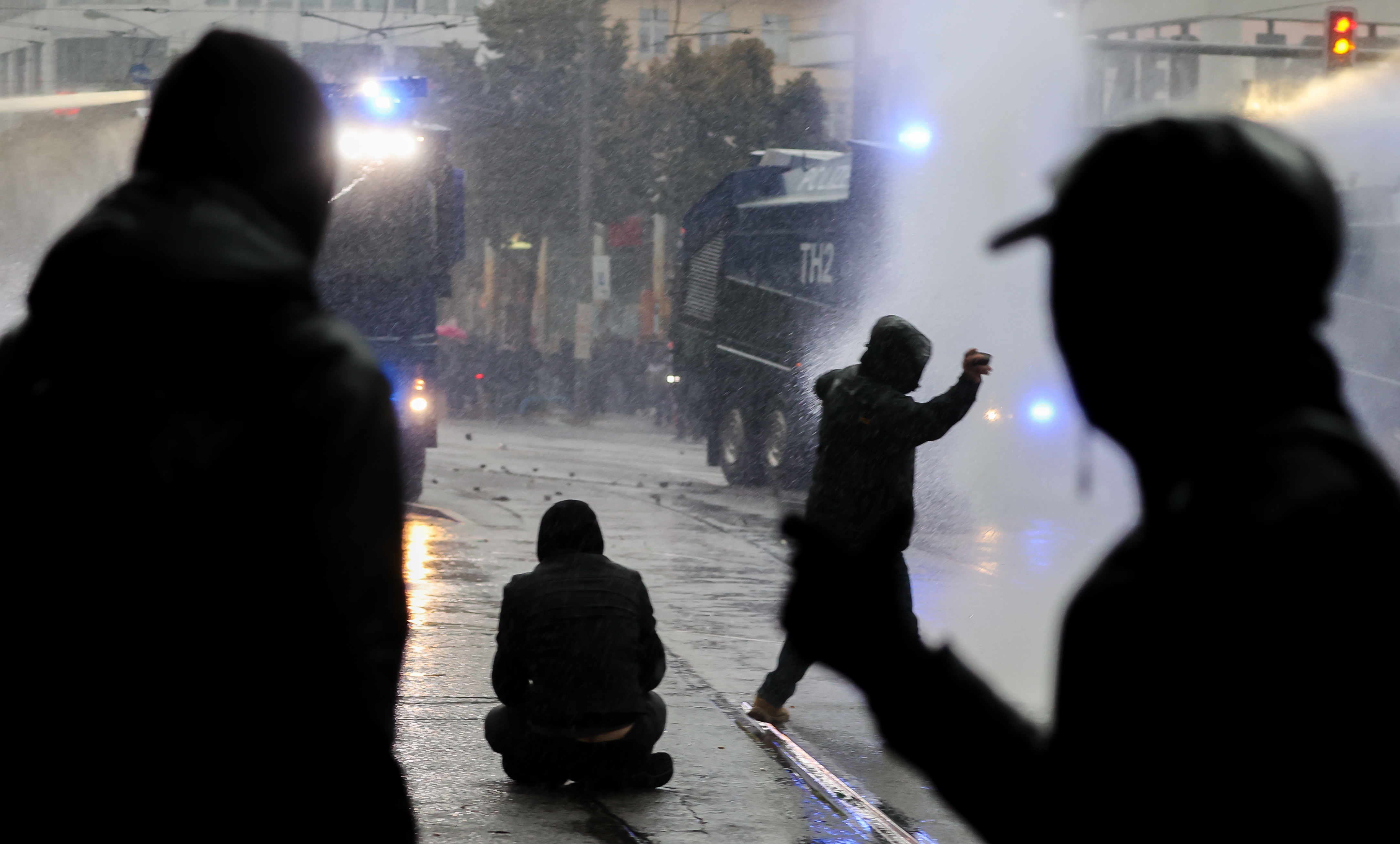 Das Bild zeigt Personen, die am 18.09.2021 in Berlin Steine gegen Polizeieinsatzfahrzeuge werfen.