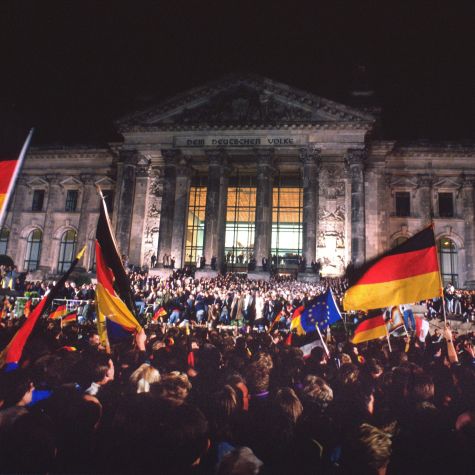 Die Aufnahme stammt vom Fest der Einheit am 2./3. Oktober 1990 in Berlin. Bei der Wiedervereinigungszeremonie vor dem Reichstag, wierden um 0.00 unter dem Jubel der Zuschauer Deutschland- und Europa-Fahnen geschwenkt.